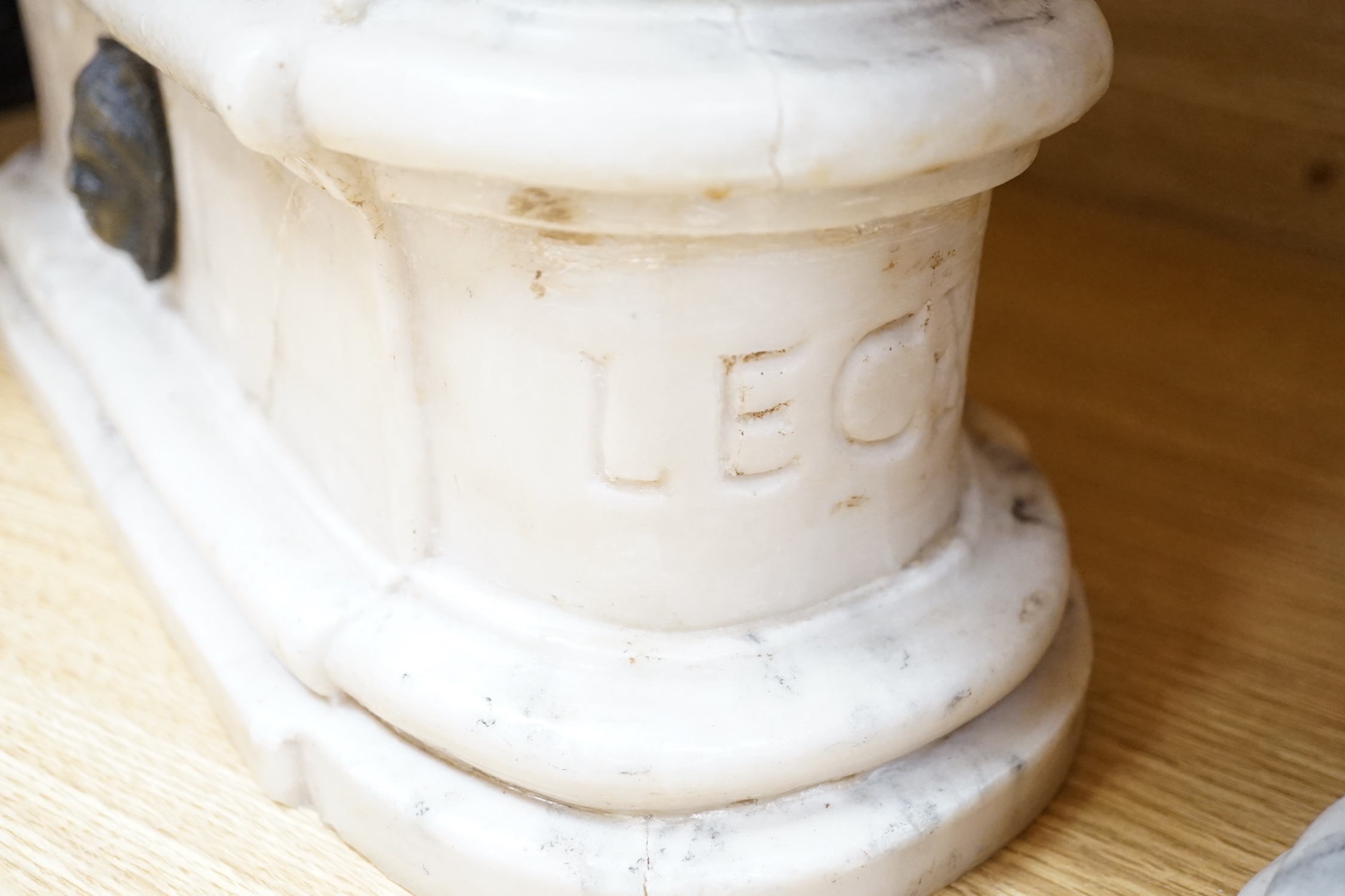 After the Antique. A pair of marble resin models of the Medici lions, each seated upon an oblong plinth, applied with bronze masks, inscribed LECXX, 41cm long, 15cm deep, 29cm high